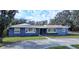 Ranch style home with blue exterior, landscaping, and circular driveway at 1705 Fredricksburg Ave, Lakeland, FL 33803