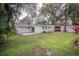 Large backyard with grassy lawn, mature trees, and a patio area at 2104 John Arthur Way, Lakeland, FL 33803