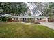 Ranch-style home with brick facade, landscaping, and driveway at 2104 John Arthur Way, Lakeland, FL 33803