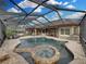 Aerial view of the screened pool area featuring a spa and backyard living spaces, perfect for entertaining and relaxation at 221 Mclean Pt, Winter Haven, FL 33884