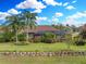 Single-Gathering home with a large backyard, tropical landscaping, and a screened patio at 221 Mclean Pt, Winter Haven, FL 33884