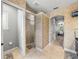 Bathroom with tiled shower stall, arched doorway, and view into bedroom with TV at 221 Mclean Pt, Winter Haven, FL 33884