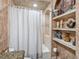 Charming bathroom featuring tiled shower, decorative shelves and a neutral colored shower curtain at 221 Mclean Pt, Winter Haven, FL 33884