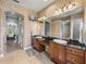 Bathroom showcasing dual sinks with dark countertops, large mirror, and access to the shower at 221 Mclean Pt, Winter Haven, FL 33884