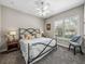 Cozy bedroom features a wrought iron bed frame and a window with white shutters, creating a relaxing retreat at 221 Mclean Pt, Winter Haven, FL 33884