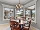 Dining area with round wood table and chandelier, overlooking the outdoor pool and patio at 221 Mclean Pt, Winter Haven, FL 33884