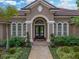 Up close home exterior view showcasing the front door, manicured landscaping, and architectural details at 221 Mclean Pt, Winter Haven, FL 33884