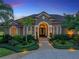 Inviting front exterior featuring a well-manicured lawn, mature landscaping, and a paved walkway leading to the front door at 221 Mclean Pt, Winter Haven, FL 33884