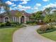 Beautiful home with a circular paver driveway, mature landscaping, and a manicured lawn at 221 Mclean Pt, Winter Haven, FL 33884