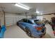Attached garage features a clean epoxy floor, plenty of storage, and a stylish blue car at 221 Mclean Pt, Winter Haven, FL 33884