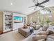Bright living room boasts built-in shelving, large windows, ceiling fan, and comfortable seating at 221 Mclean Pt, Winter Haven, FL 33884