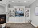 Elegant living room featuring a fireplace and custom built-in shelving and entertainment center at 221 Mclean Pt, Winter Haven, FL 33884