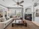 Comfortable living room with a ceiling fan, fireplace, and large windows with natural lighting at 221 Mclean Pt, Winter Haven, FL 33884