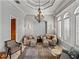 Formal living room with crown molding, chandelier and shuttered windows at 221 Mclean Pt, Winter Haven, FL 33884