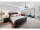 Spacious primary bedroom featuring a tray ceiling, large windows, and a seating area at 221 Mclean Pt, Winter Haven, FL 33884