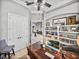 Office space with wood desk, white shelving, and a view into the living area at 221 Mclean Pt, Winter Haven, FL 33884