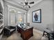 Office with dark wood desk, shutters on windows and art on the wall at 221 Mclean Pt, Winter Haven, FL 33884