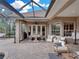 Inviting covered outdoor area with a dining table, comfortable seating, a grill, and an outdoor kitchen setup at 221 Mclean Pt, Winter Haven, FL 33884