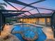 Twilight view of the pool area showcases the spa and backyard living spaces under a screened enclosure at 221 Mclean Pt, Winter Haven, FL 33884