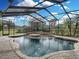 A screened-in pool with a spa, surrounded by stone and landscaping, offers a relaxing outdoor oasis at 221 Mclean Pt, Winter Haven, FL 33884
