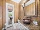 Unique powder room with decorative walls, stylish sink, and access to the outdoor pool area at 221 Mclean Pt, Winter Haven, FL 33884