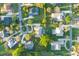 Aerial view of a landscaped property with a screened-in pool surrounded by well-kept lawns and mature trees at 2428 Wildwood Ct, Winter Haven, FL 33884