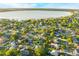 Aerial view of a home near a lake, surrounded by lush greenery with a black navigation pin on the property at 2428 Wildwood Ct, Winter Haven, FL 33884