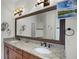 Double vanity bathroom with granite countertops and large mirror at 2428 Wildwood Ct, Winter Haven, FL 33884