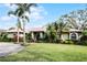 Landscaped one-story home with palm trees and a circular driveway at 2428 Wildwood Ct, Winter Haven, FL 33884