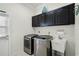 Laundry room with washer, dryer, cabinets, and sink at 2428 Wildwood Ct, Winter Haven, FL 33884