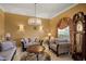 Elegant living room featuring a chandelier, neutral-toned furniture, and large windows at 2428 Wildwood Ct, Winter Haven, FL 33884