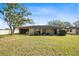 Expansive backyard with green lawn, covered patio, golf cart, and partial view of home at 25 Aviation Dr, Winter Haven, FL 33881