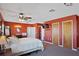 Primary bedroom with ceiling fan, double doors, and en-suite bathroom at 25 Aviation Dr, Winter Haven, FL 33881