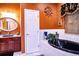 Bathroom with black soaking tub and rich brown vanity at 3001 Crystal Beach Rd, Winter Haven, FL 33880