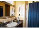 Bathroom with vanity, ornate mirror, and blue shower curtain at 3001 Crystal Beach Rd, Winter Haven, FL 33880