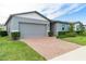 Gray house with gray garage door and brick paver driveway at 3285 Weitzel Dr, Haines City, FL 33844