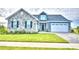 Two-story home with stone and blue siding, a two-car garage, and a landscaped lawn at 337 Doryman Way, Auburndale, FL 33823