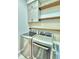 Modern laundry room with washer, dryer, and stylish wooden shelves at 337 Doryman Way, Auburndale, FL 33823