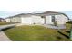 Front view of a house with a gray roof, white siding, and a landscaped yard at 347 Towns Circle, Haines City, FL 33844