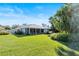 Home's backyard features a large green lawn and screened porch at 38 Grenewood Ln, Haines City, FL 33844