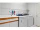 Bright laundry room with washer, dryer and shelving at 38 Grenewood Ln, Haines City, FL 33844