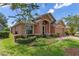 House exterior showcasing a peach-colored facade, lush landscaping and American flag at 4068 Carteret Dr, Winter Haven, FL 33884