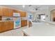 Bright kitchen featuring wood cabinets, a large island, and a double sink at 4068 Carteret Dr, Winter Haven, FL 33884