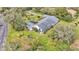 Aerial view shows a single-story house with a large backyard and surrounding trees at 48 Nottingham Way, Haines City, FL 33844
