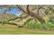 Relaxing garden area with a metal bench under a large oak tree at 48 Nottingham Way, Haines City, FL 33844