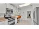 Modern kitchen with stainless steel appliances and orange barstools at 48 Nottingham Way, Haines City, FL 33844