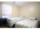 Bedroom with twin beds, desk, and window with curtains at 5090 Misty Lake Dr, Mulberry, FL 33860