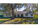 Single-story home with a large tree and manicured lawn at 5090 Misty Lake Dr, Mulberry, FL 33860