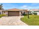 House exterior with brown garage door and brick accents at 515 Sweetwater Way, Haines City, FL 33844