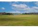 Expansive view of the golf course with a pond and lush green fairways under a blue sky at 523 Brookeshire Dr, Davenport, FL 33837